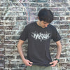 A person wearing a heavyweight black RAYGUN t-shirt with the brand name in stylized, spiky white lettering.