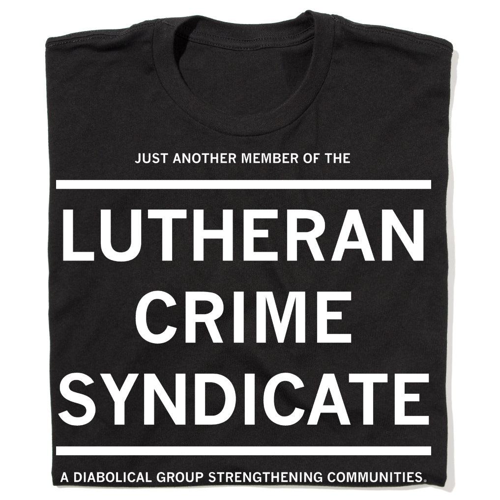 Folded black t-shirt with white text that reads "JUST ANOTHER MEMBER OF THE LUTHERAN CRIME SYNDICATE. A DIABOLIC GROUP STRENGTHENING COMMUNITIES"