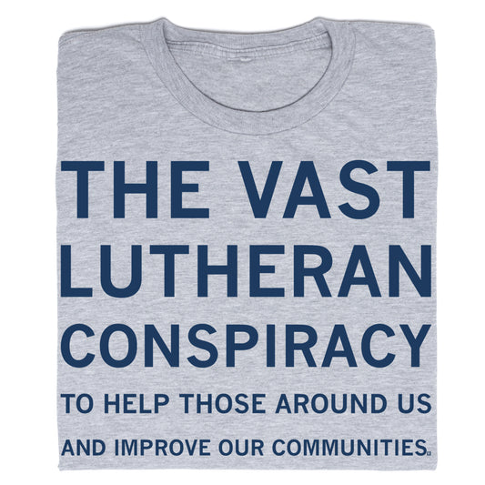 A gray union-made t-shirt with navy blue text reading: THE VAST LUTHERAN CONSPIRACY TO HELP THOSE AROUND US AND IMPROVE OUR COMMUNITIES.