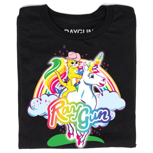 Black Pride T-shirt featuring a graphic of a yellow cat in a pink cowboy hat riding a white unicorn in front of a rainbow and clouds, with the text RayGun below.