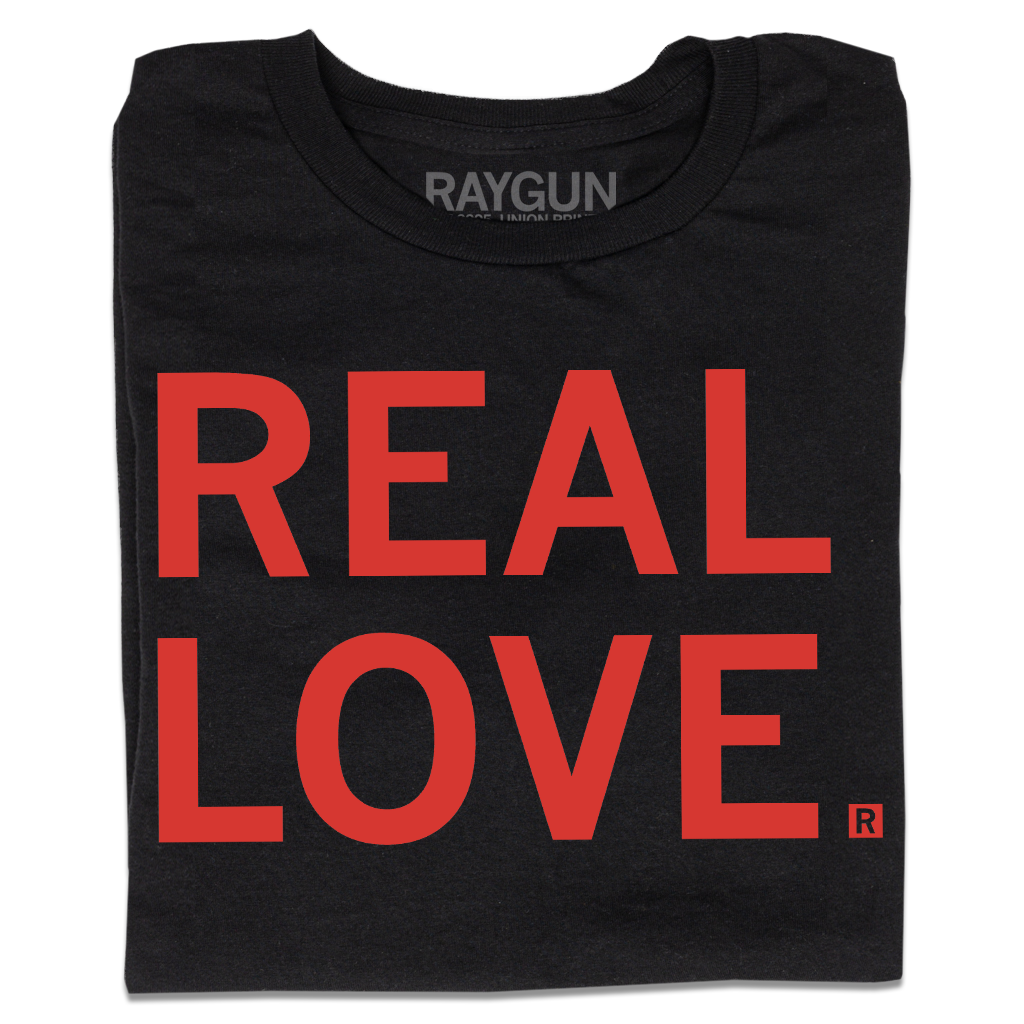 A folded black t-shirt with all-caps red text that says, "REAL LOVE."