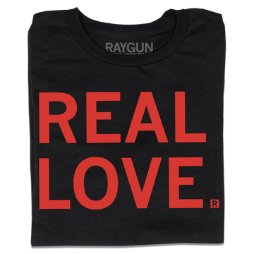 A folded black t-shirt with all-caps red text that says, "REAL LOVE."