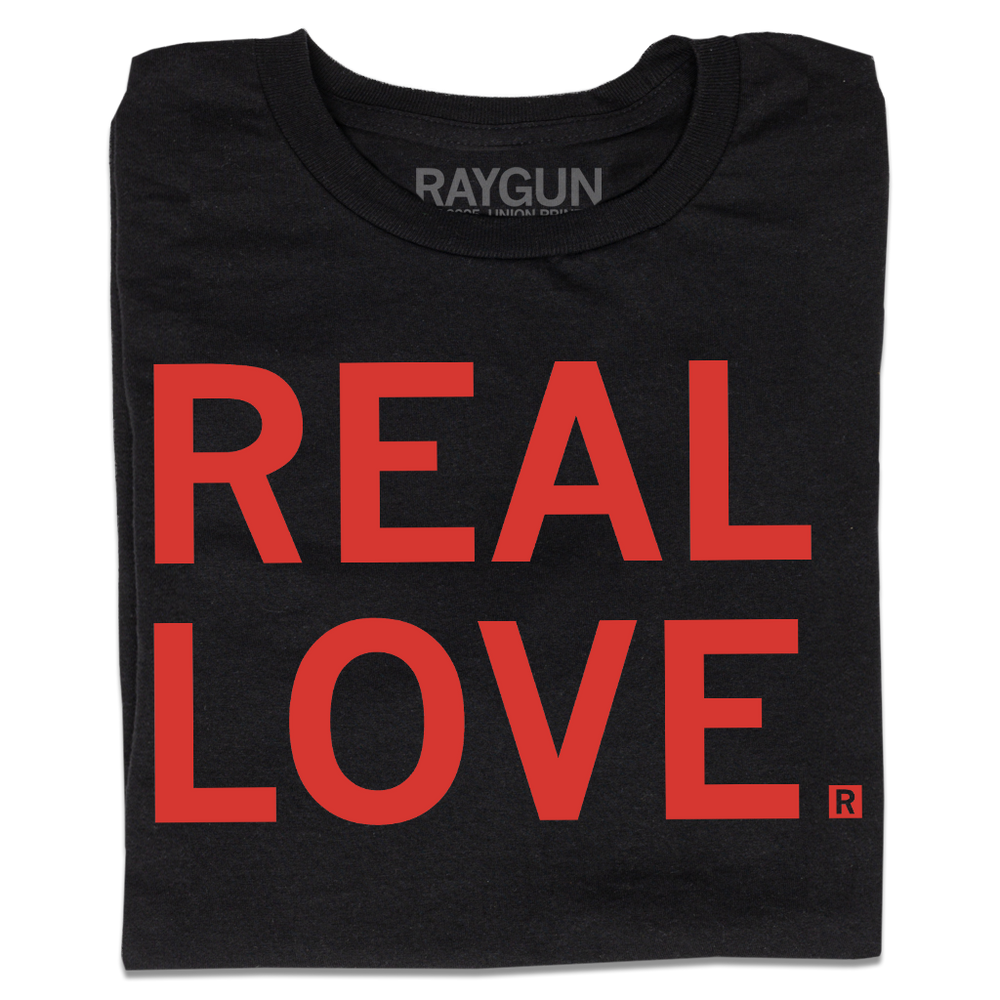 A folded black t-shirt with all-caps red text that says, "REAL LOVE."