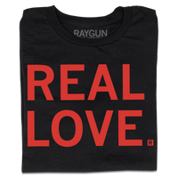 A folded black t-shirt with all-caps red text that says, "REAL LOVE."
