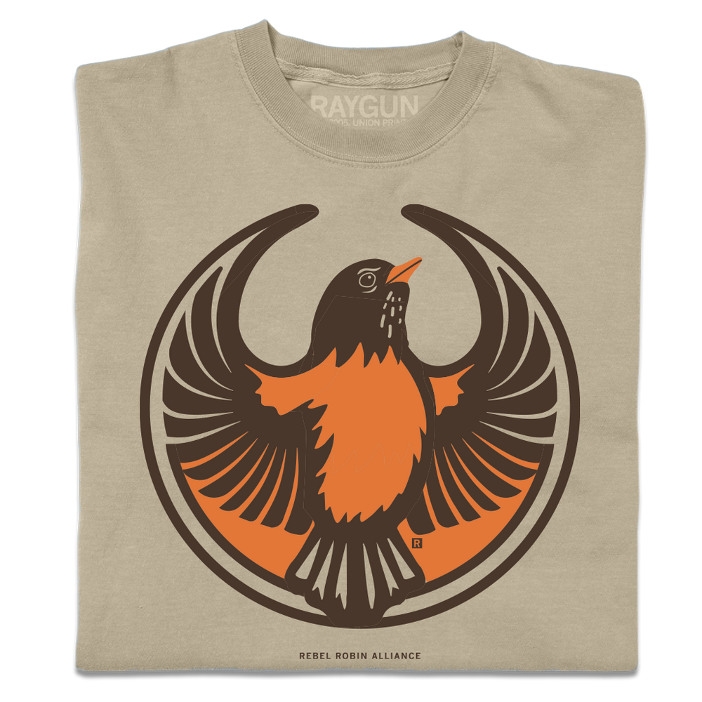 A folded heavyweight khaki shirt with the Rebel American Robin Alliance Logo. It uses a american robin with outstretched wings to mimic the shape of the Star Wars Rebel Alliance Logo. The american robin is printed in orange and brown ink.
