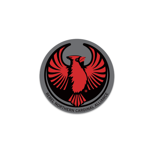 Circular Rebel Northern Cardinal emblem featuring a stylized red cardinal with spread wings and the text REBEL NORTHERN CARDINAL ALLIANCE along the bottom edge, in the style of a RAYGUN vinyl sticker.