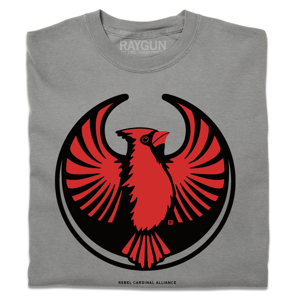 A folded heavyweight grey shirt with the Rebel Northern Cardinal Alliance Logo. It uses a northern cardinal with outstretched wings to mimic the shape of the Star Wars Rebel Alliance Logo. The northern cardinal is printed in red and black ink.