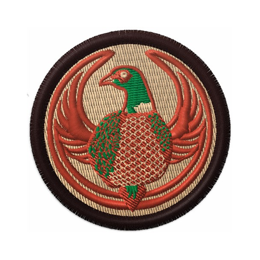 An embroidered circle patch with the Rebel Pheasant Alliance Logo. It uses a pheasant with outstretched wings to mimic the shape of the Star Wars Rebel Alliance Logo. The pheasant green and light brown. The border of the patch is a dark brown and the rest of the patch is beige.
