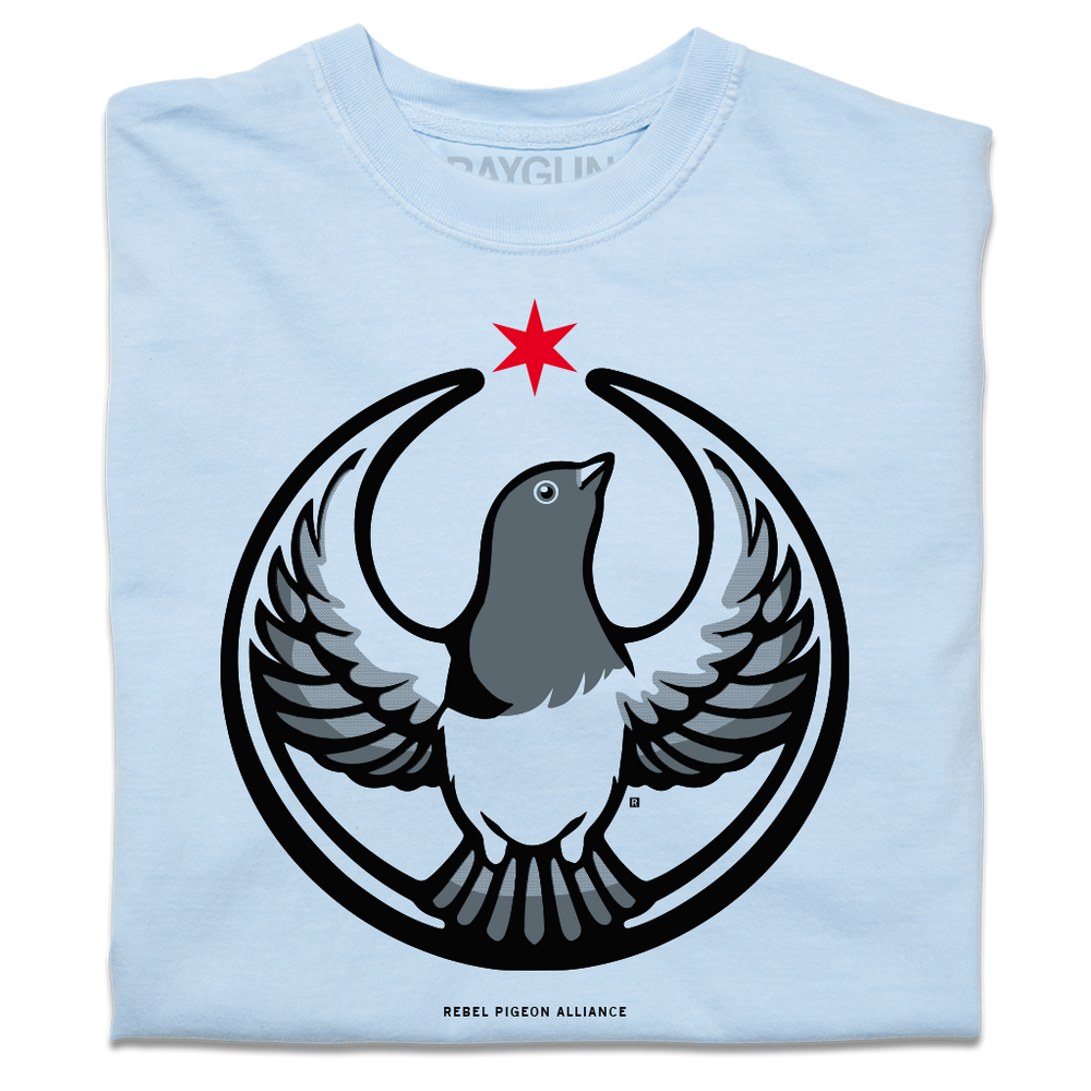 A folded heavyweight light blue shirt with the Rebel Pigeon Alliance Logo. It uses a pigeon with outstretched wings to mimic the shape of the Star Wars Rebel Alliance Logo. The pigeon is printed in black and grey with a red star above its head.