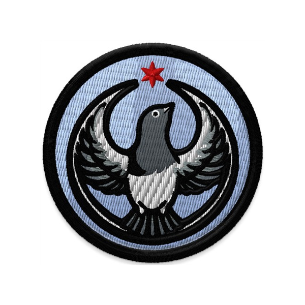 Circular patch with the Rebel Pigeon Alliance Logo. It uses a pigeon with outstretched wings to mimic the shape of the Star Wars Rebel Alliance Logo. The pigeon is black, white, and grey with a red Chicago star above its head. The border of the patch is black and the rest of the patch is sky blue.