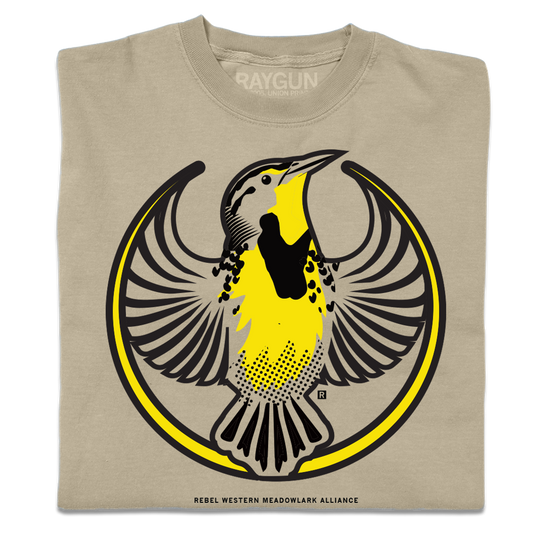 A folded heavyweight khaki shirt with the Rebel Western Meadowlark Alliance Logo. It uses a western meadowlark with outstretched wings to mimic the shape of the Star Wars Rebel Alliance Logo. The western meadowlark is printed in black and gold ink.
