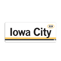 Retro style rectangular sticker. White base with a yellow oval in the top right surrounding "319" in black print. Black text to the left says, "Iowa City" with yellow and black lines below that.