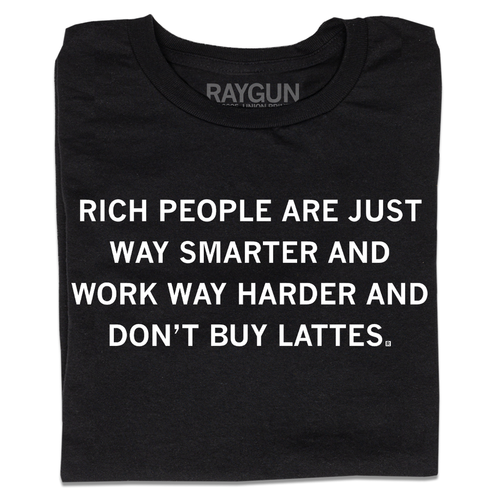 A folded black t-shirt with centered white ink text that says, "Rich people are just way smarter and work way harder and don't buy lattes."