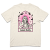 Comfort Colors ivory heavyweight t-shirt with pink & black print depicting Dolly Parton with her arms outstretched. A stained glass frame is around her, with a pink sun behind her, black butterflies around her, and text at the bottom that says, "SAINT DOLLY."
