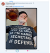 A man with a white goatee and glasses wears a RAYGUN t-shirt that reads, Im going to stop drinkin just as soon as Im named Secretary of Defense, while holding a glass of amber liquid and smoking a cigar.