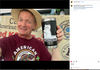A man in a straw hat and maroon t-shirt holds a black Yeti tumbler decorated with a Caffeinated AF vinyl sticker of a cat drinking coffee.
