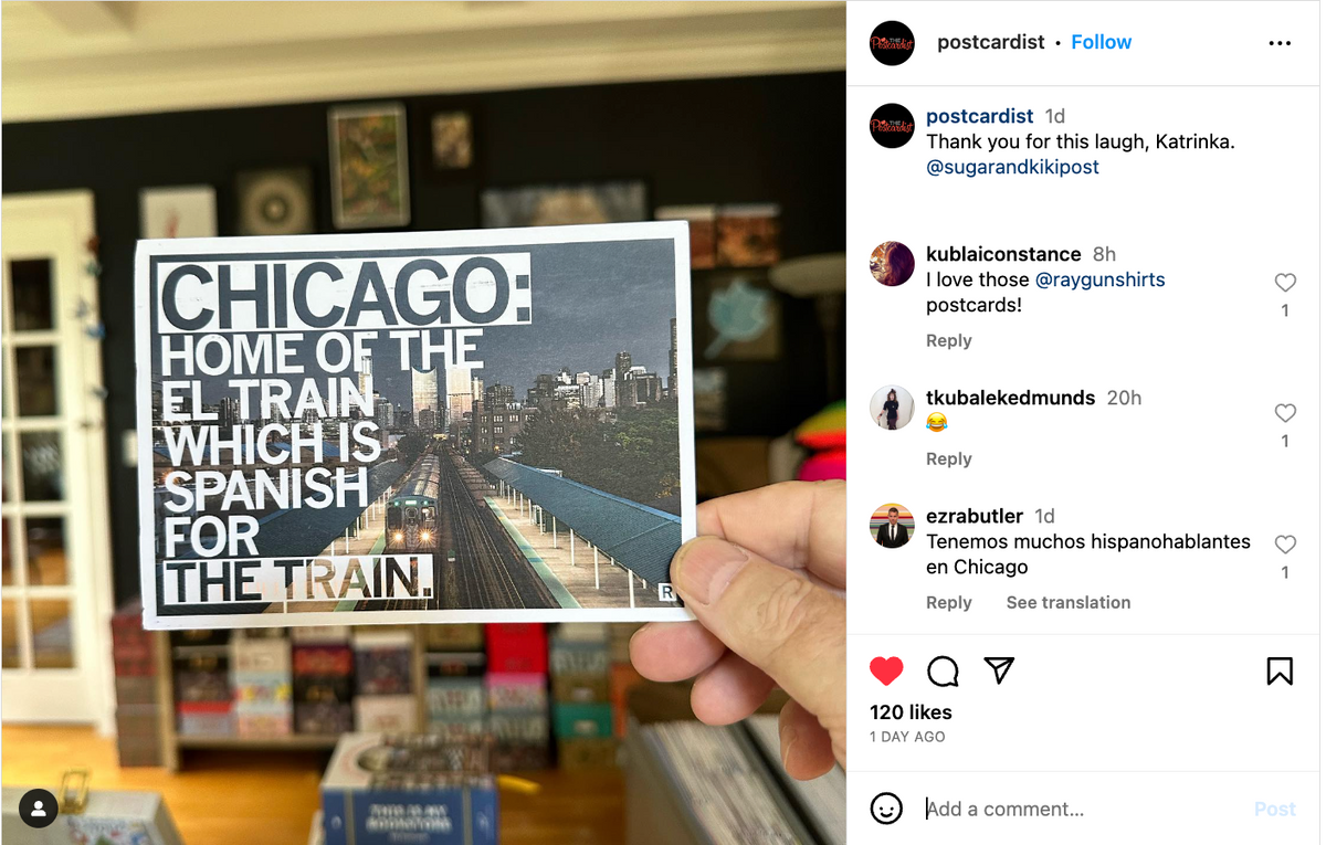 A hand holds a Chicago postcard featuring a photo of an elevated train track with the text, Chicago: Home of the El train, which is Spanish for the train.