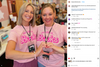 Two women smiling in matching, union-made pink shirts that read My job is... Books and forming a heart shape with their hands.