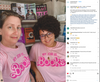 Two people standing in front of a bookshelf, both wearing matching union made, sweatshop free pink shirts that read My job is... BOOKS.