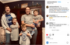 A family of five posing in front of a dark wood hutch, wearing matching gray RAYGUN t-shirts that say Griff We Trust.