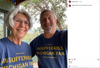 An older woman and man smile for a selfie while wearing matching blue RAYGUN T-shirts that read Just another insufferable Michigan fan.