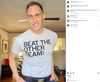 A man smiling while wearing a union made RAYGUN t-shirt that says BEAT THE OTHER TEAM!.