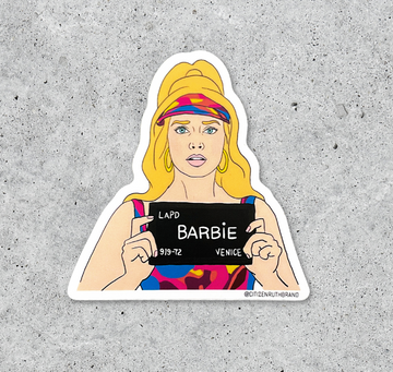 Waterproof vinyl sticker of a blonde woman in a colorful outfit holding an LAPD booking sign that reads BARBIE.