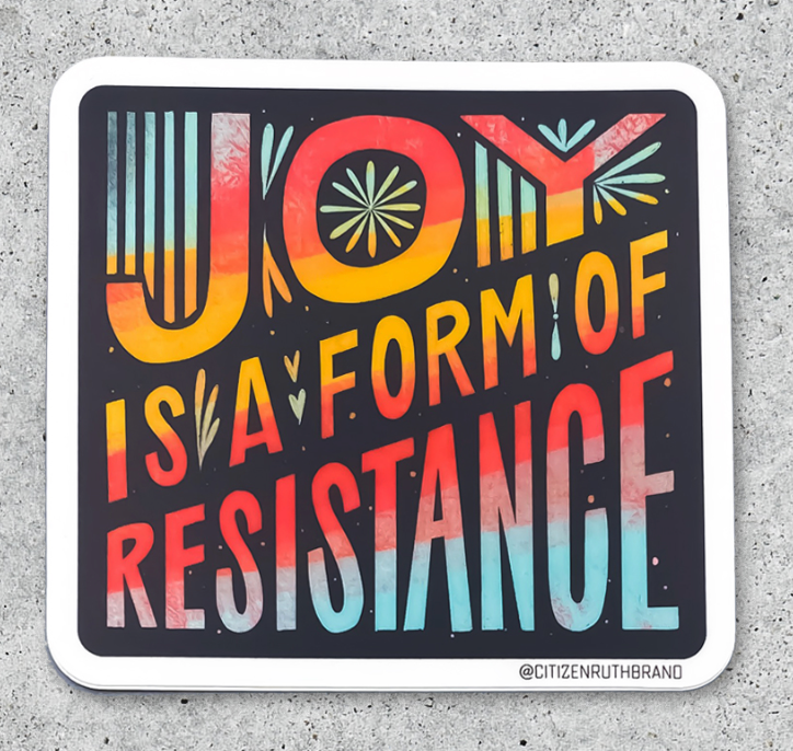 Square Citizen Ruth vinyl sticker that reads, JOY IS A FORM OF RESISTANCE in colorful, stylized lettering against a dark background.