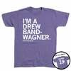 Short-sleeve heather purple t-shirt with left-aligned white text that reads "I'M A DREW BAND-WANGER" above smaller text that says, "DREW WAGNER" with a small outline of Illinois that has 19 in its center. A circle image in the bottom right corner shows the back of the t-shirt printed like a jersey with "WAGNER" above 19.