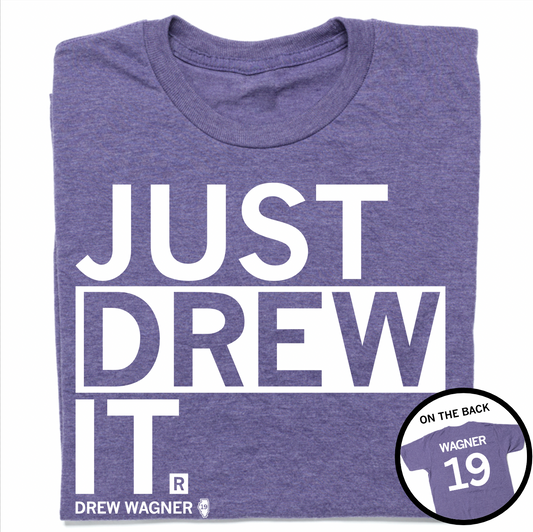 A folded heather purple t-shirt with left-aligned white text that reads "JUST DREW IT" above smaller text that says, "DREW WAGNER" with a small outline of Illinois that has 19 in its center. A circle image in the bottom right corner shows the back of the t-shirt printed like a jersey with "WAGNER" above 19.