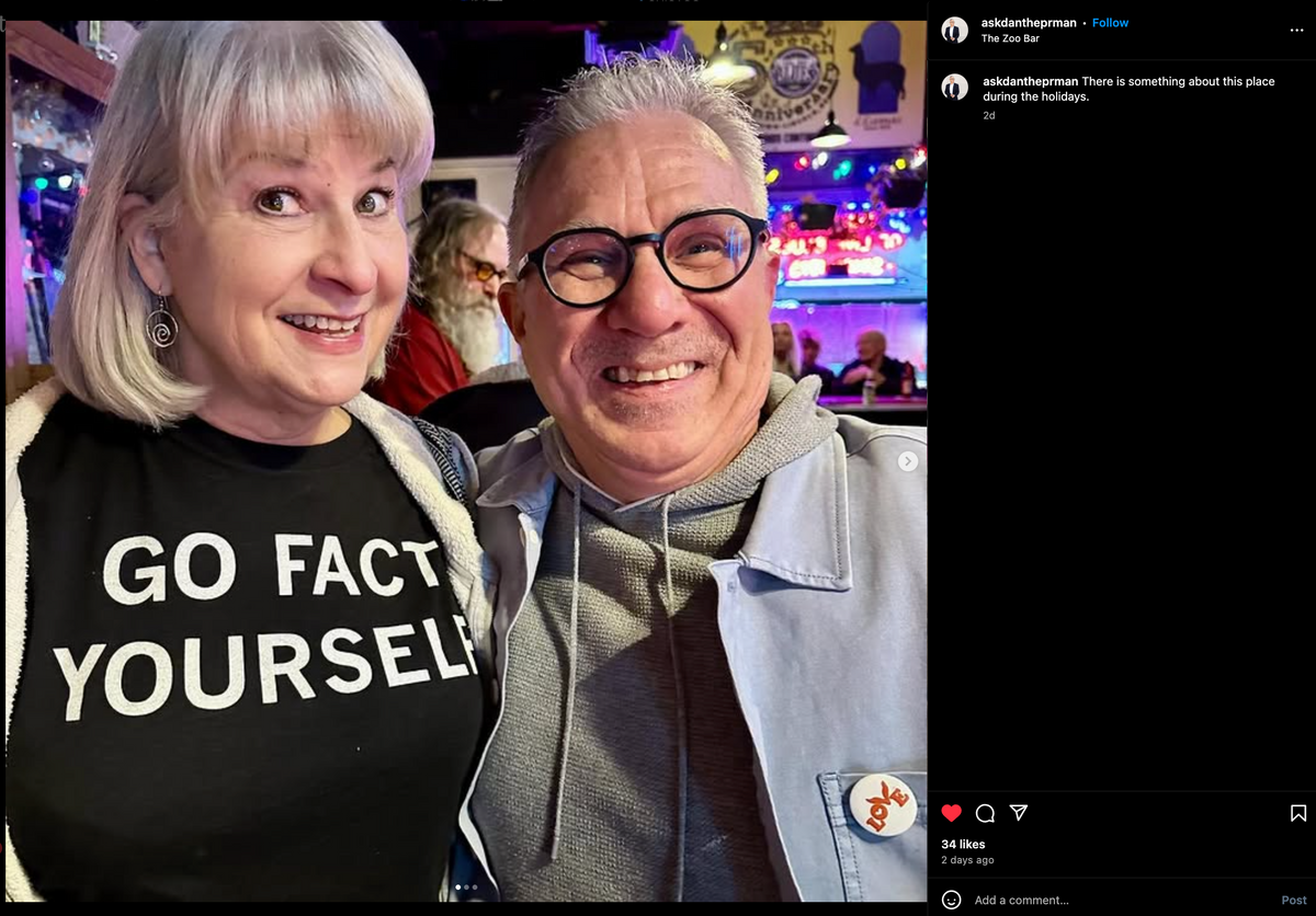 A smiling man and woman pose for a photo in a bar; the woman wears a union made Go Fact Yourself t-shirt.