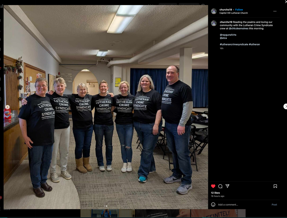 Seven people stand in a line wearing matching union made t-shirts that read Lutheran Crime Syndicate.