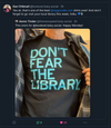 A person wearing a sweatshop-free black t-shirt that says DONT FEAR THE LIBRARY in large, light blue letters.