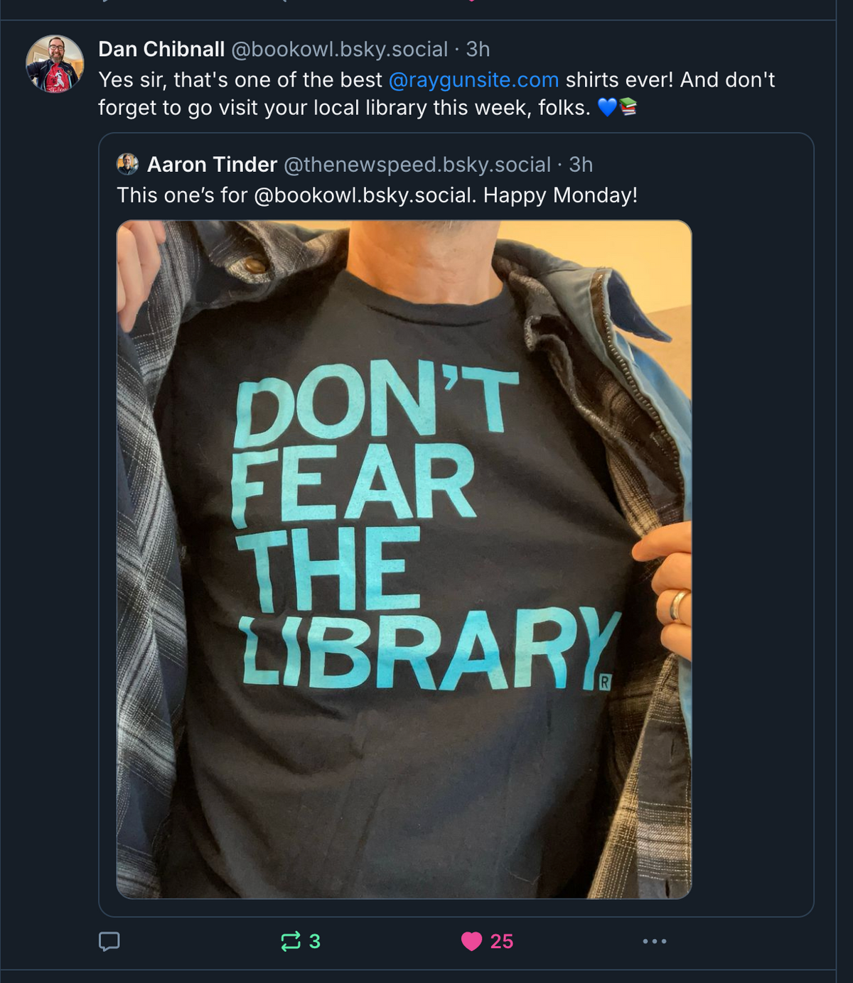 A person wearing a sweatshop-free black t-shirt that says DONT FEAR THE LIBRARY in large, light blue letters.
