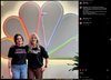 Two women stand in front of a glowing NBC logo; the person on the left wears a union made Lets Go Lesbians t-shirt, and the person on the right wears a shirt that says Support + Feed.