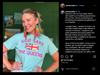 A woman wearing a heather purist blue t-shirt that says GOD SAVE THE QUEENS with a Union Jack icon and long, multicolored fringe earrings.
