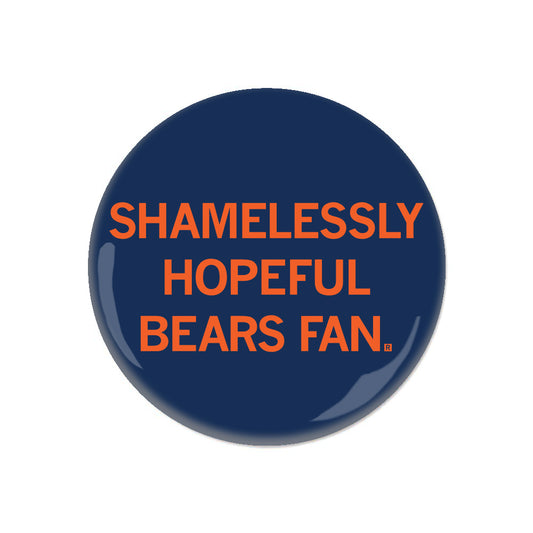 A circular navy blue RAYGUN metal button with orange text that reads SHAMELESSLY HOPEFUL BEARS FAN.