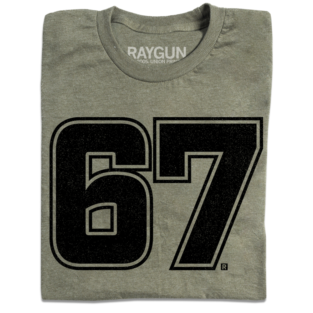 A folded heather military green shirt with giant "67" printed in black ink in the center.