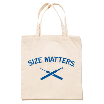 Beige 100% cotton canvas tote bag with a royal blue screen print of the text SIZE MATTERS above an illustration of two crossed crochet hooks.