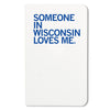 White RAYGUN notebook with the blue text SOMEONE IN WISCONSIN LOVES ME. printed on the cover.