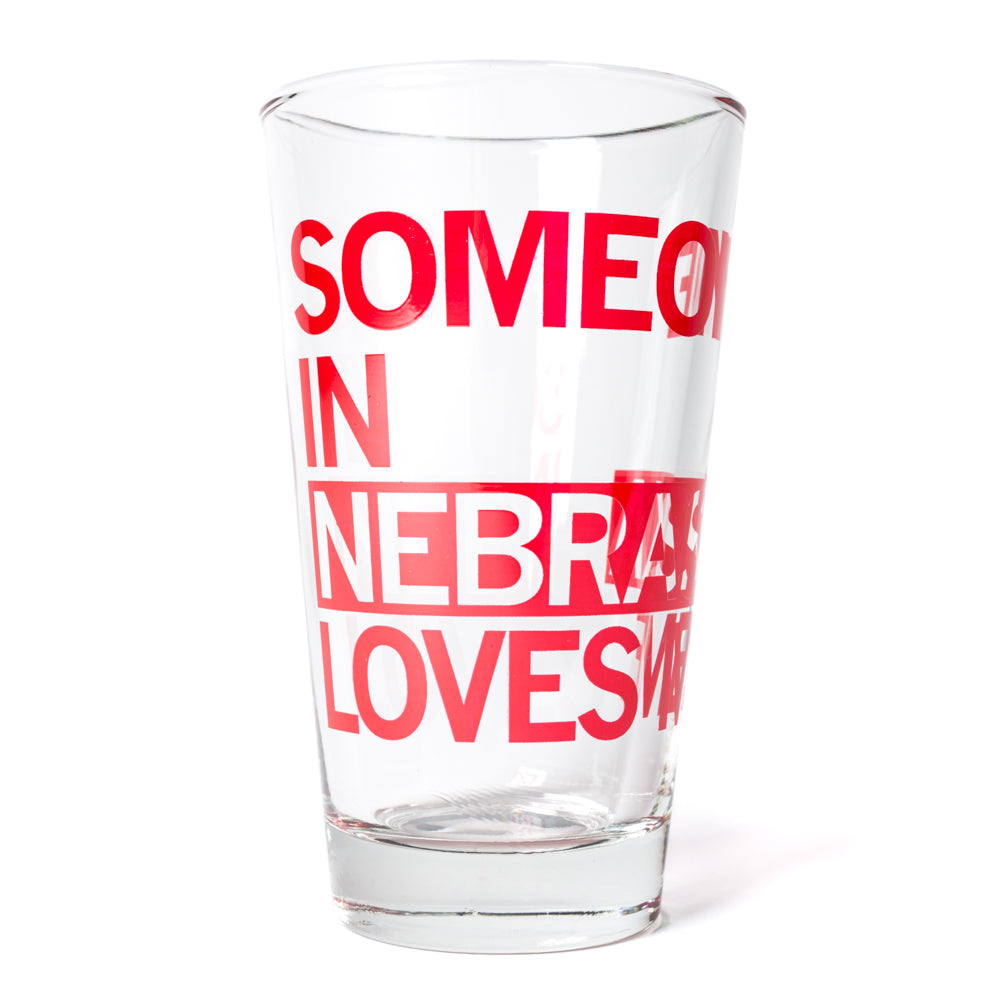 Clear, dishwasher-safe drinking glass printed with the red text SOMEONE IN NEBRASKA LOVES ME.