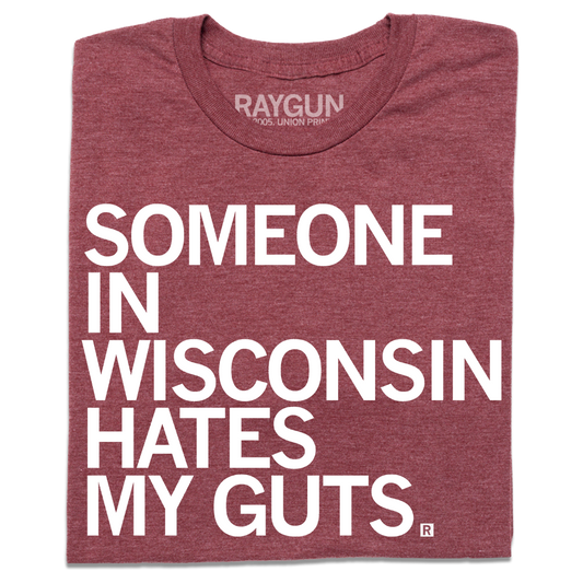 A folded heather burgundy t-shirt with left aligned white ink that says, "Someone in Wisconsin hates my guts" in all caps.