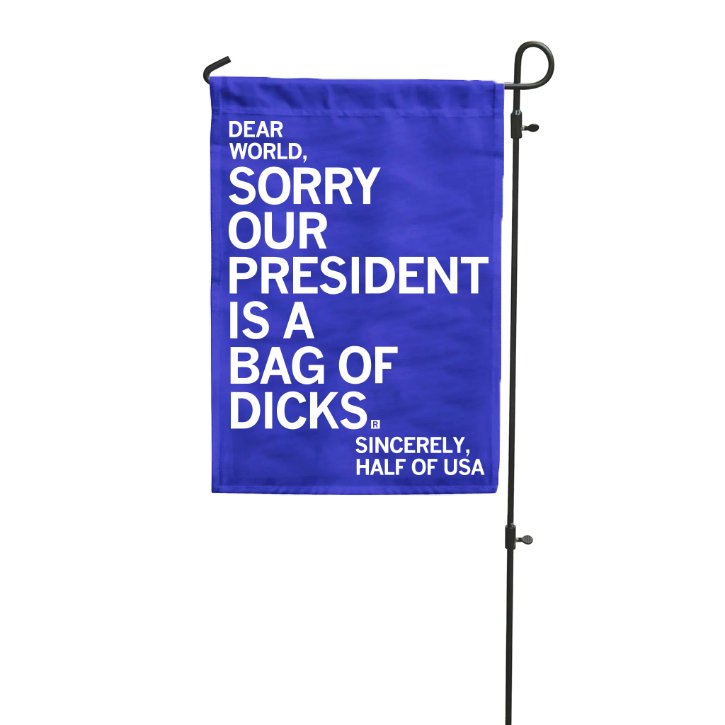 A blue garden flag that reads, Dear World, Sorry Our President Is A Bag Of Dicks. Sincerely, Half Of USA. This political flag features bold white text.