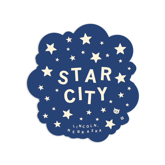 A navy blue Star City vinyl sticker with a cloud-like edge, featuring cream-colored text reading STAR CITY and LINCOLN, NEBRASKA, surrounded by stars and a small cat face.