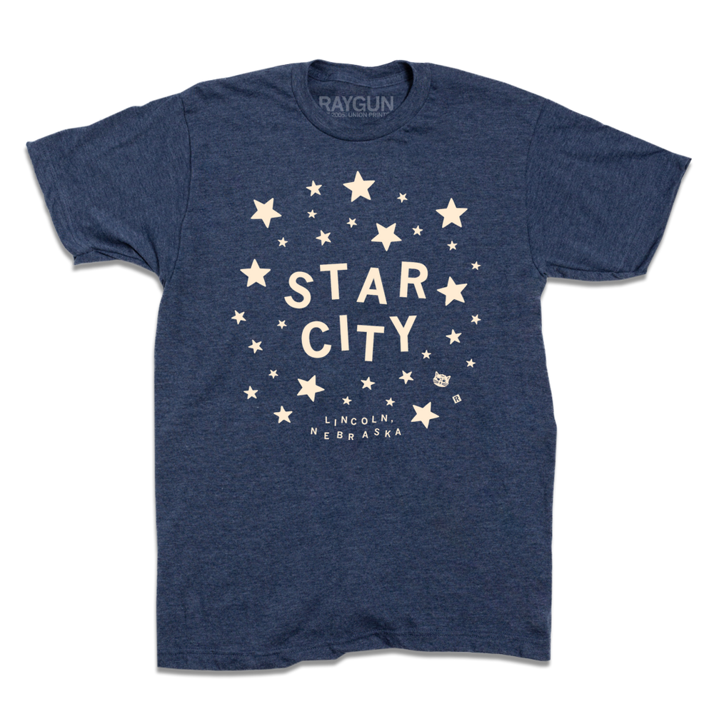 Heather denim t-shirt with glow in the dark ink that reads "Star City. Lincoln, Nebraska" surrounded by stars.