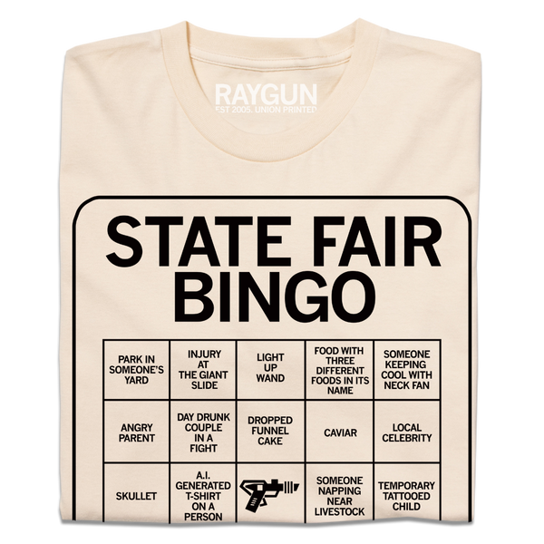 A folded off white shirt with black print depicting a bingo card. All caps text at the top of the card says, 