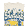 A heavyweight cream-colored t-shirt with a graphic that reads IOWA DOES IT BUTTER and STATE in blue lettering, featuring a yellow cow, a blue ribbon, and a basket of food.