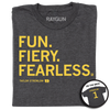 A folded heather charcoal shirt with gold left aligned in that reads "Fun. Fiery. Fearless. Taylor Stremlow 1" on the front and "Stremlow 1" printed on the back like a jersey.