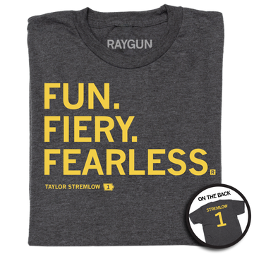 A folded heather charcoal shirt with gold left aligned in that reads "Fun. Fiery. Fearless. Taylor Stremlow 1" on the front and "Stremlow 1" printed on the back like a jersey.