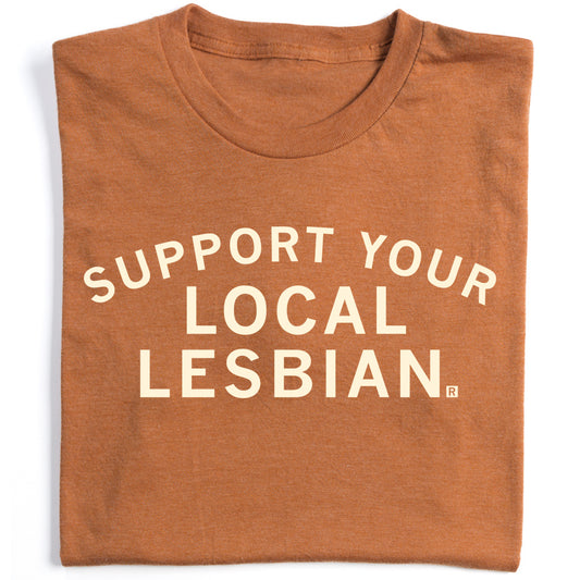 Folded rust-colored, union-made t-shirt with the text SUPPORT YOUR LOCAL LESBIAN printed in white letters on the front.
